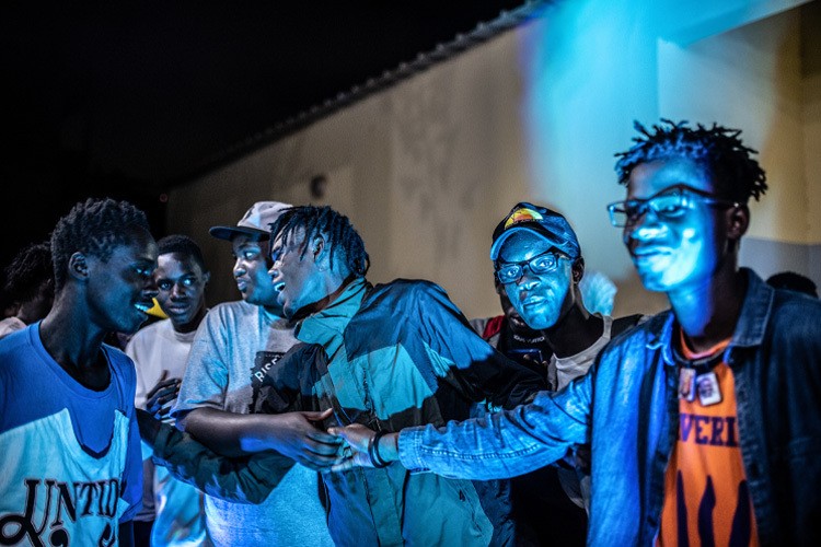 A group of young men smiling and talking.