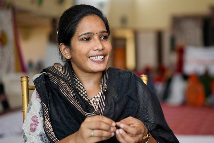 Shazia, a young woman smiling and wearing a black scarf across her shoulders, was photographed at AMIED's workshop in Kishangarhbaas, India, August 2022. Photo by Deepak Sharma.